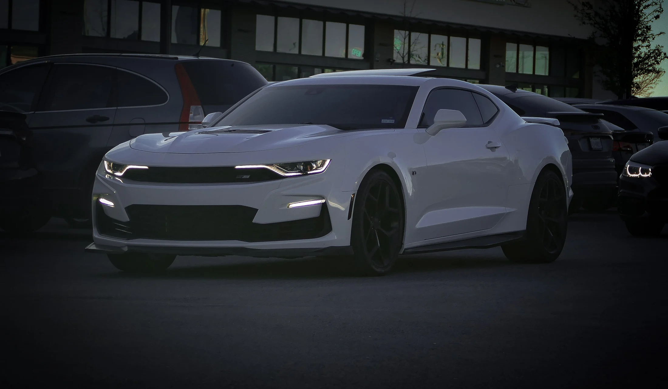 White performance coupe at dusk