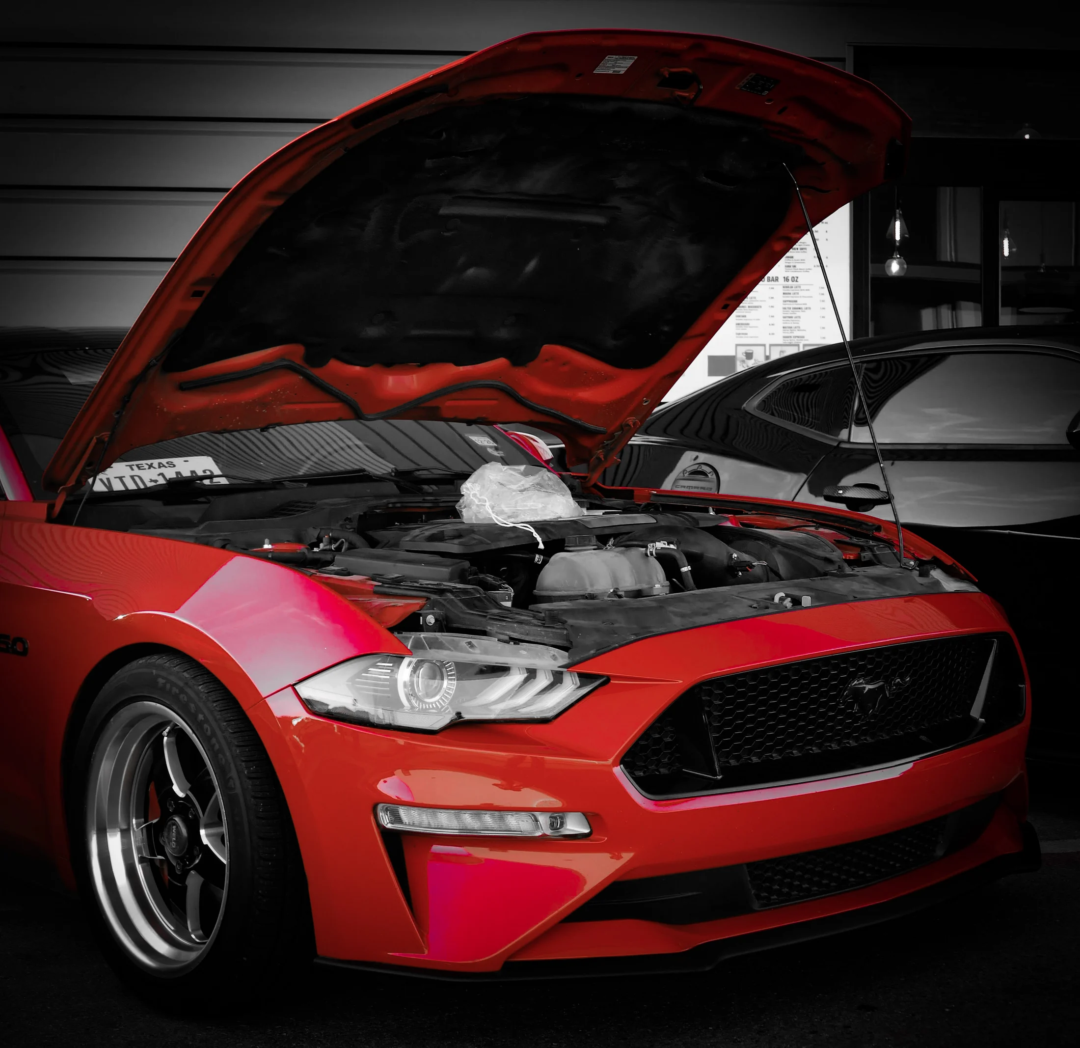 Red Ford Mustang displayed with its hood open