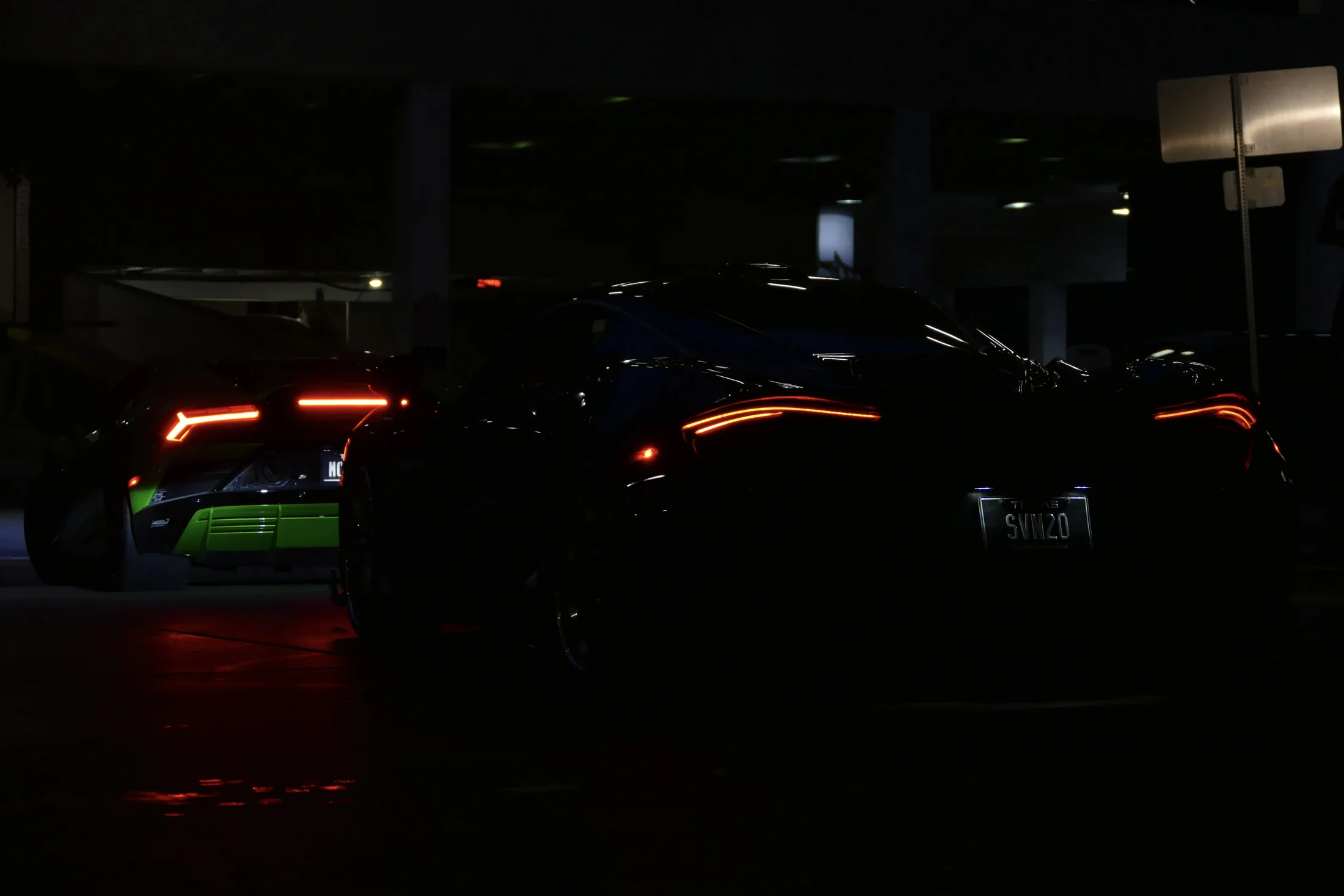 Supercars illuminated by taillights at night